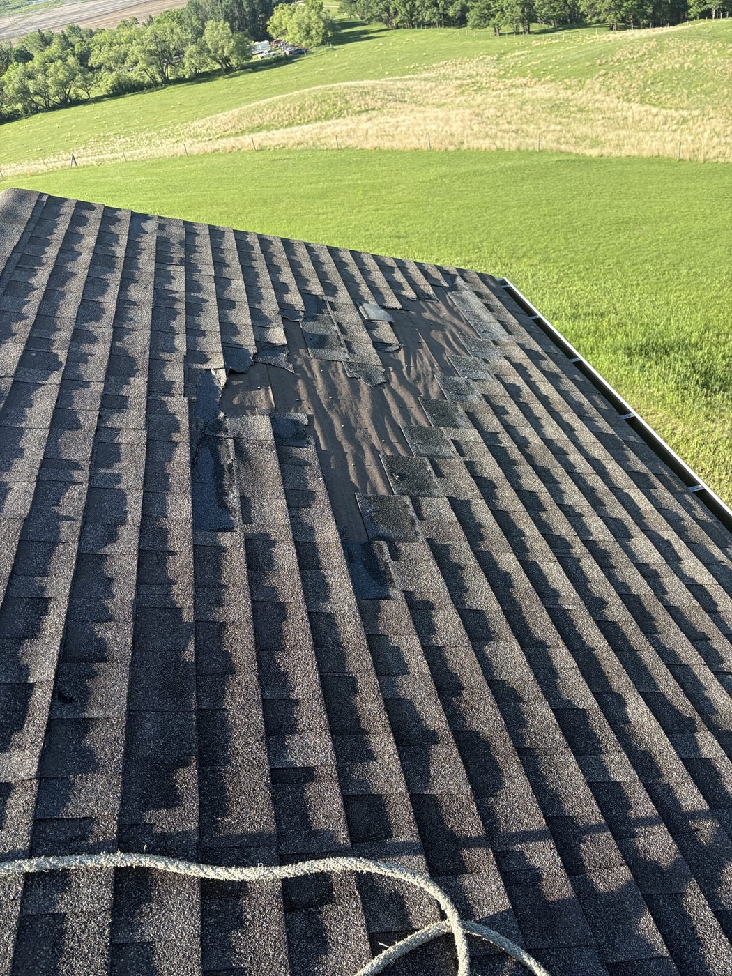 Wind-damaged shingles on a Westman roof after a storm